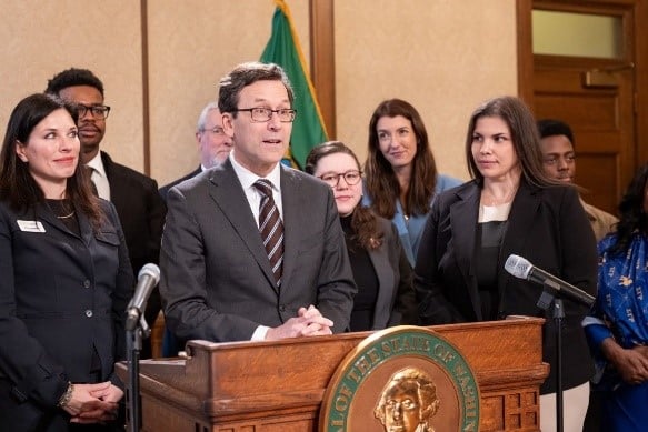 Meegan Brooks (rear, in blue) joined supporters of CEMA reform with Washington Gov. Bob Ferguson. Washington Retail Association Director of Policy and Government Affairs Crystal Leatherman is shown to the right of Meegan.