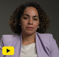 An image of Emilia McKee Vassallo beside a play button.